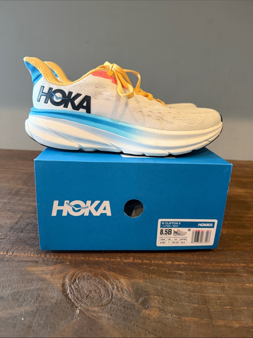 Hoka Women’s Clifton 9 White Sneakers with Blue & Yellow Accents